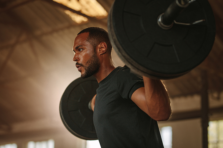 Picture of a young male lifting weights at the gym.