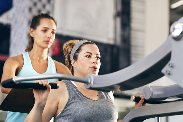 Picture of two women working out at the gym.