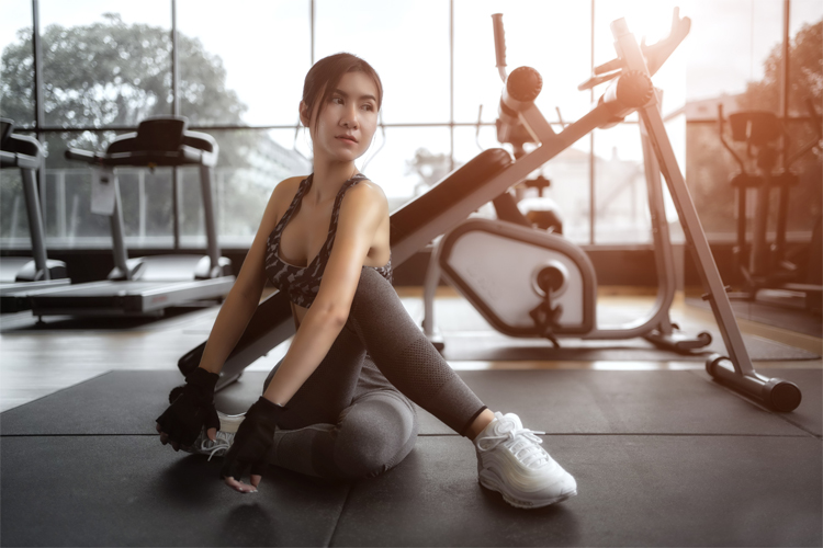 Image of a young woman exercising on a mat at the gym.