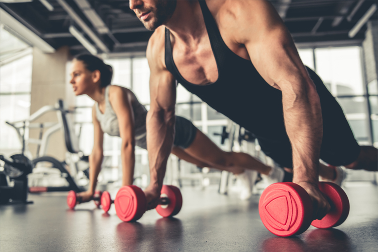 Image of a man and woman doing press up with weights.