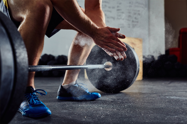 Image of a man lifting weights in a gym.