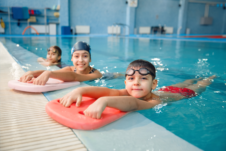 Image of Kids in a swimming pool with kick boards.