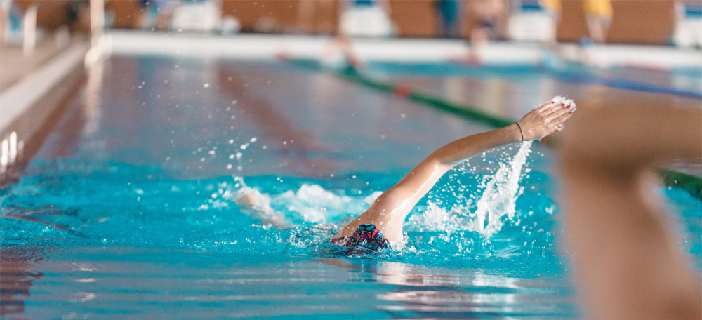 Image of a young man swimming in a pool.